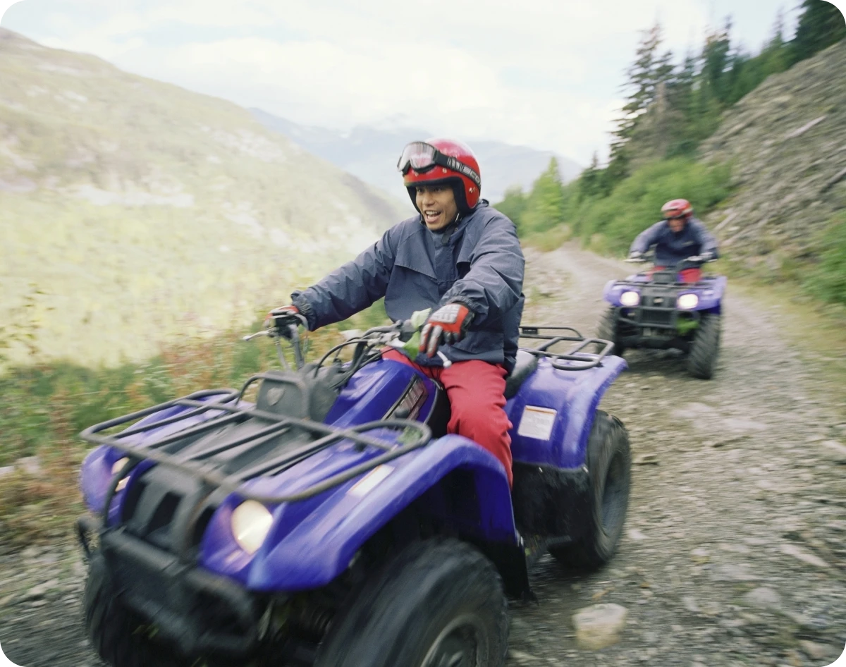 People riding ATVs on a mountain trail.